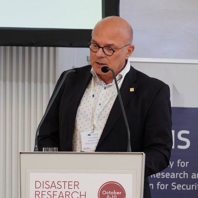 Univ.-Prof. Dr. Robert Galler, Mann mit runder Brille und dunklem Anzug, moderiert ein Panel bei den Disaster Research Days 2024 in Wien. Galler ist Leiter des Lehrstuhls für Subsurface Engineering an der Montanuniversität Leoben.