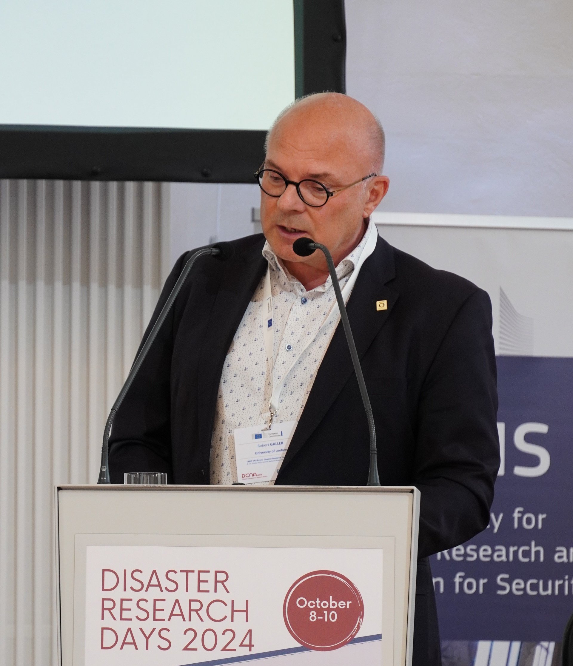 Univ.-Prof. Dr. Robert Galler, Mann mit runder Brille und dunklem Anzug, moderiert ein Panel bei den Disaster Research Days 2024 in Wien. Galler ist Leiter des Lehrstuhls für Subsurface Engineering an der Montanuniversität Leoben.