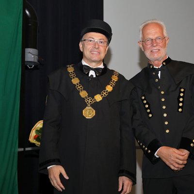 Rektor Wilfried Eichlseder und der neue Professor für Legierungsdesign von Leichtmetallen Peter Uggowitzer im Bergkittel bzw. Talar auf der Bühne des Erzherzog-Johann-Auditoriums