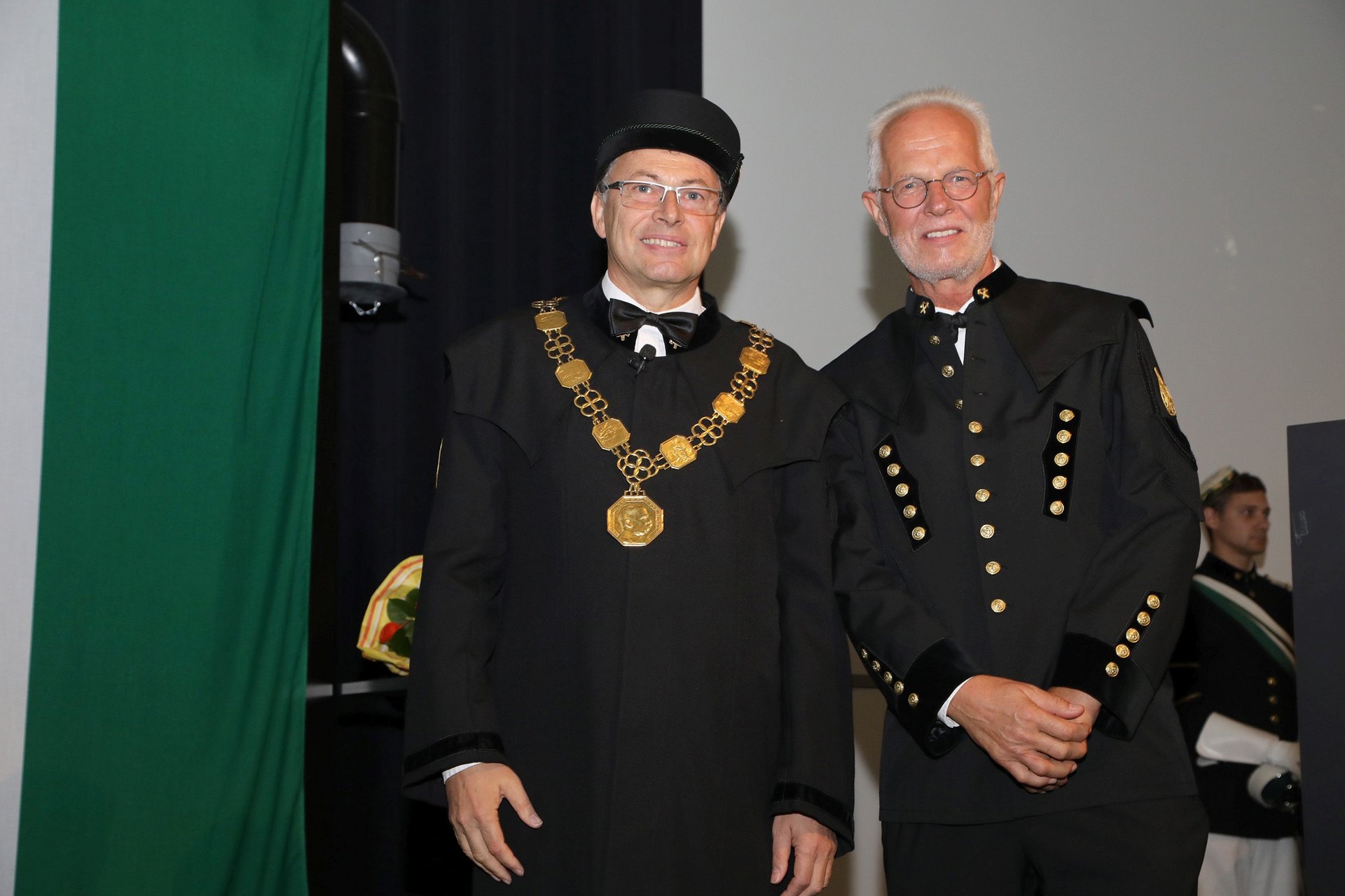 Rektor Wilfried Eichlseder und der neue Professor für Legierungsdesign von Leichtmetallen Peter Uggowitzer im Bergkittel bzw. Talar auf der Bühne des Erzherzog-Johann-Auditoriums