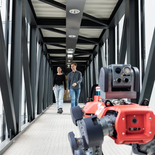 Foto: © MUL Zwei Studenten im Gang mit einem Roboterhund.