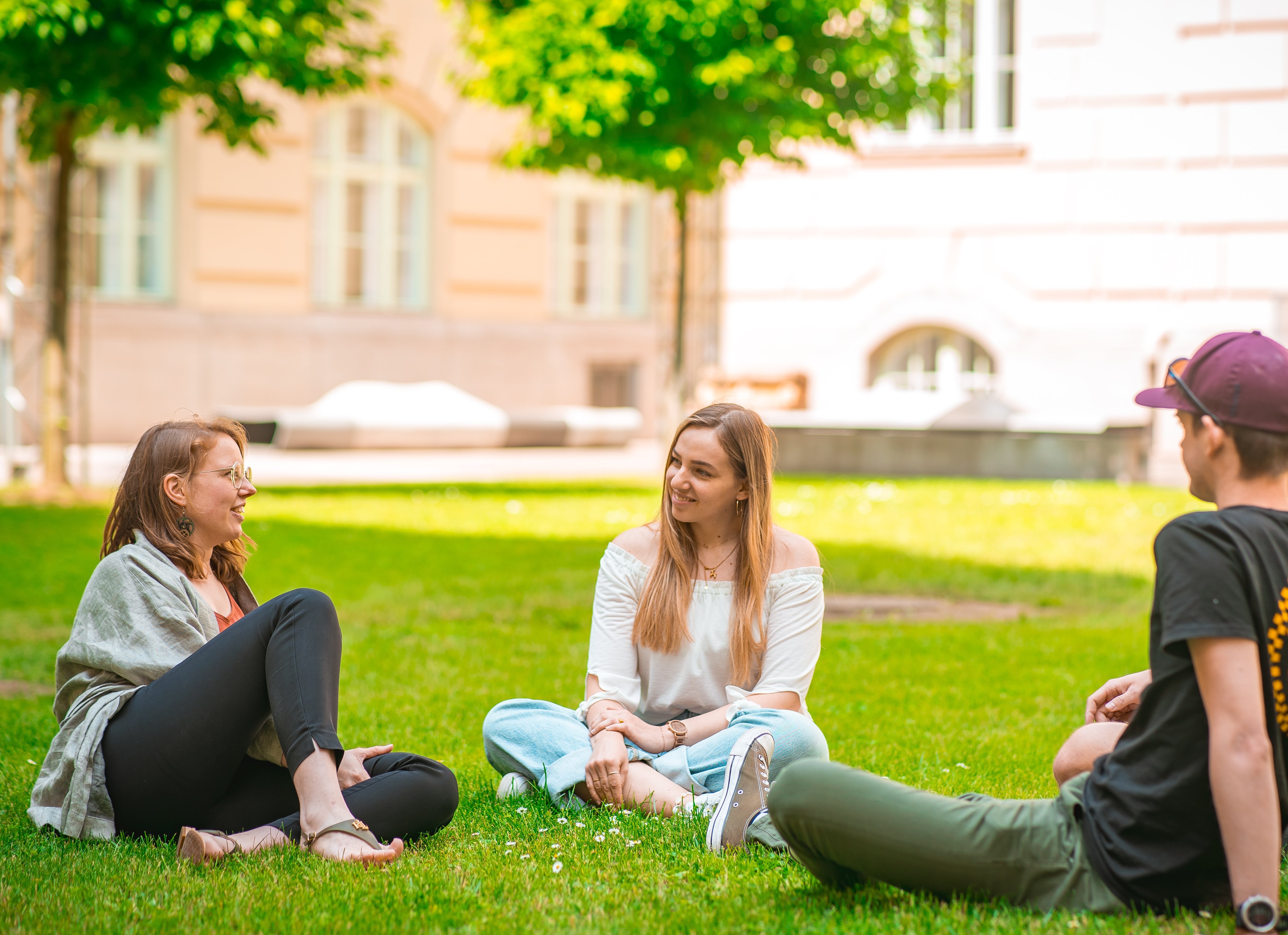 Studenten auf einer Wiese im Innenhof der Montanuniversität Leoben.