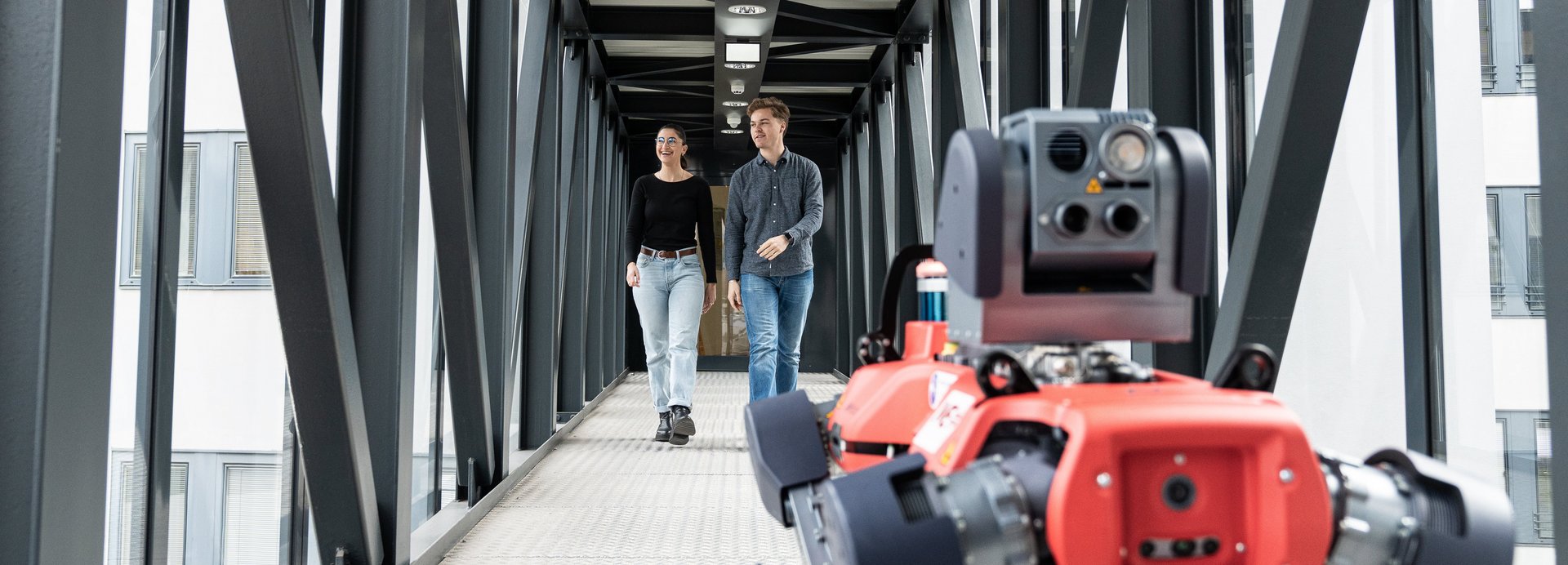 Zwei Studenten und ein Roboterhund im Gang der Montanuni.