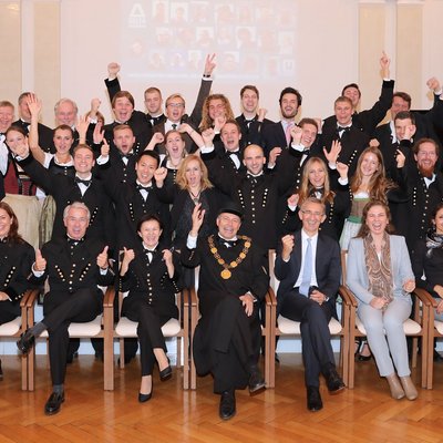 Gruppenfoto, aufgenommen in der Aula der Montanuniversität. Jubelnde Studierende und Ehrengäste feiern die Zertifikats-Verleihung.