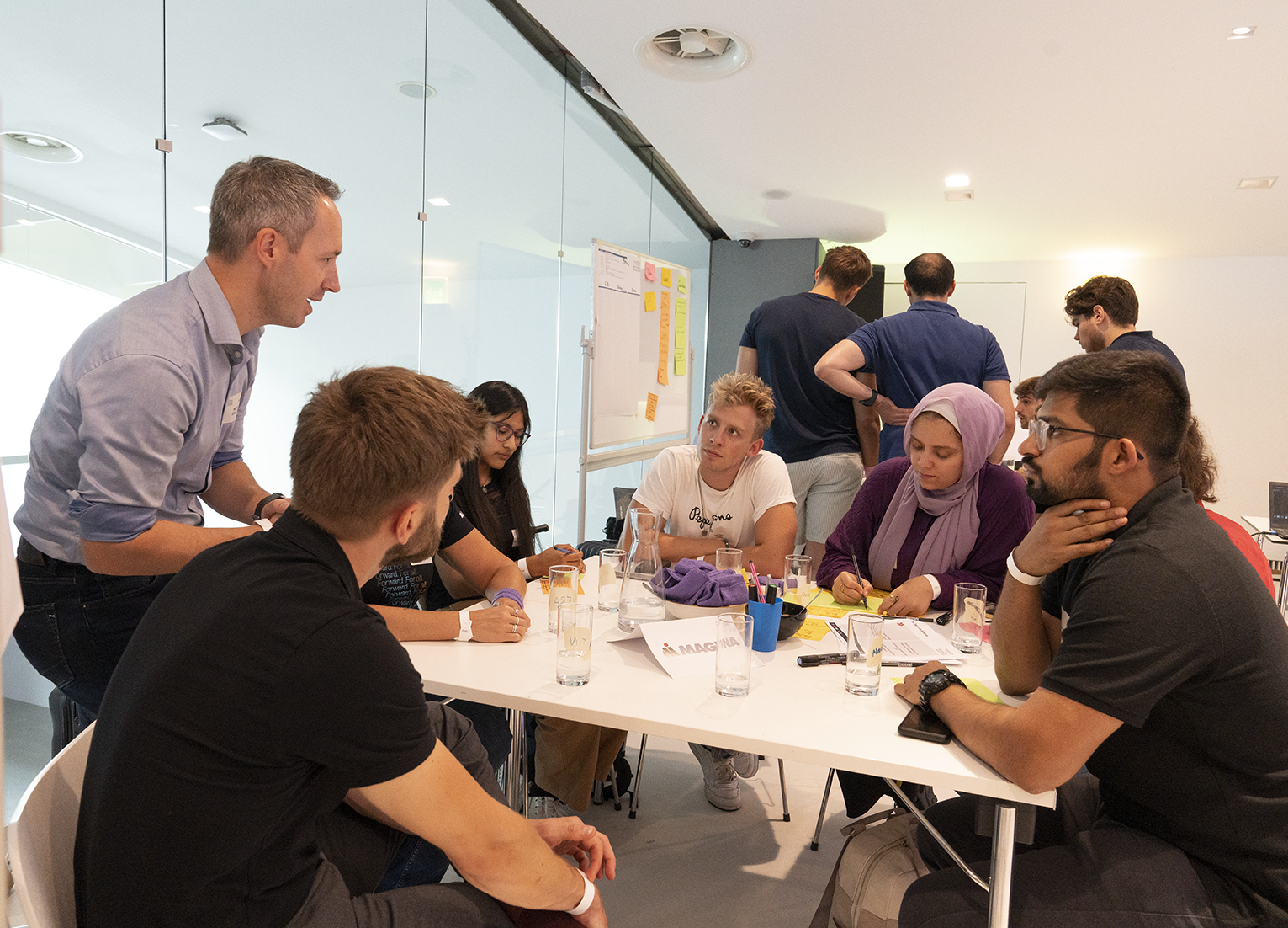 Gruppe von Menschen, die in einem Büro eine Besprechung abhalten anlässlich des Innovationsmarathons der TU Austria.