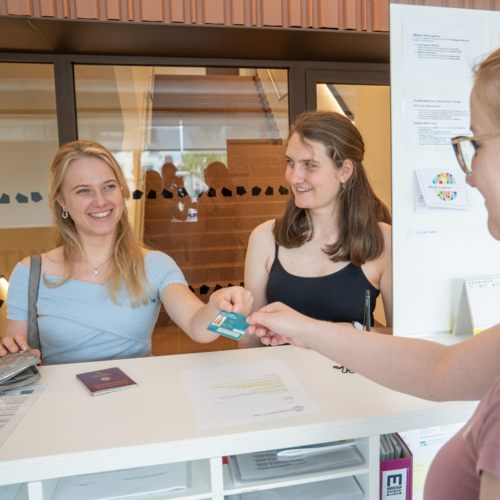 Zwei Studentinnen erhalten ihren MU Online Ausweis der Montanuniversität Leoben.