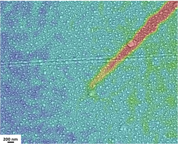 Die Spitze eines „gefangenen“ Scherbandes im metallischen Palladium-Silizium-Glas. Die lokale Dehnung ist durch die Farbskala dargestellt, wobei die hohe plastische Verformung durch das Scherband mit roter Farbe gekennzeichnet ist. Ohne die Darstellung der Oberflächendehnung wäre das Scherband nicht sichtbar, da keine Veränderung der Oberfläche stattgefunden hat. © Foto: MUL