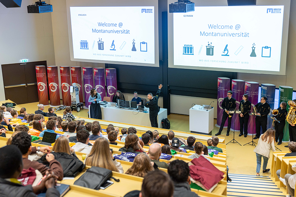 Vortragende und Hörer in einem Hörsaal an einer technischen Universität.